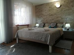 a bedroom with a bed and a brick wall at Cichy Zakątek in Wilkasy