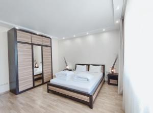 - une chambre blanche avec un lit et un miroir dans l'établissement Positive, à Lviv