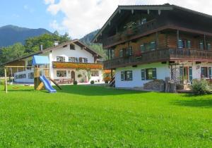 uma casa grande com um parque infantil em frente em Haus Wiesenrand Kurz em Berchtesgaden