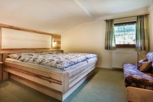 a bedroom with a large bed and a couch at Haus Wiesenrand Kurz in Berchtesgaden