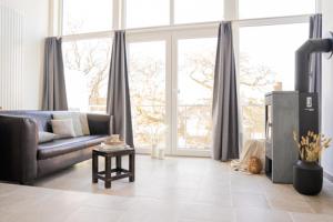 a living room with a couch and a large window at Meerhotel Großenbrode in Großenbrode