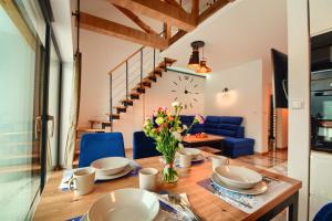 a dining room with a table with chairs and a clock at Apartament Marmurowy w Szczyrku z widokiem na góry z dostępem do sauny i jacuzzi w weekendy , dwa miejsca parkingowe in Szczyrk