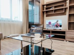 een kamer met een glazen tafel en een laptop erop bij Positive in Lviv
