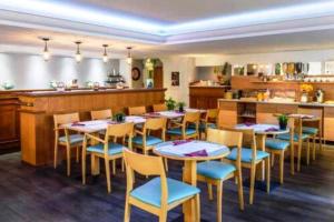 Un restaurante con mesas y sillas y un mostrador. en Monaco à 300m du Casino - Grand Studio avec Piscine, en Beausoleil
