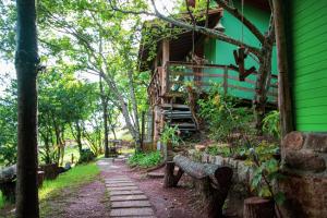 a house in the woods with a path leading up to it at Chalé Siriú - entre o rio e o mar in Siriú