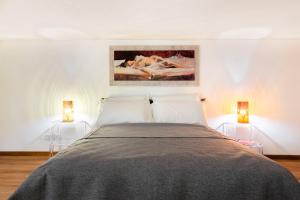 a bedroom with a large bed with two lamps at Rotonda 23 - Loft in Pantheon in Rome