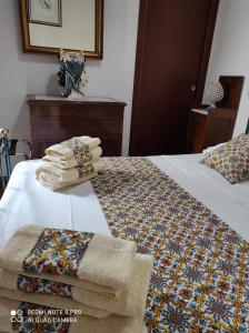 1 dormitorio con 2 camas y toallas. en B&B Il Padrino, en Savoca