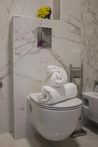 a bathroom with a toilet and a sink and towels at Villa Hodžić in Mostar +29 photos