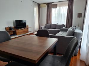 a living room with a table and a couch at Apartman Esperanza in Vrnjačka Banja