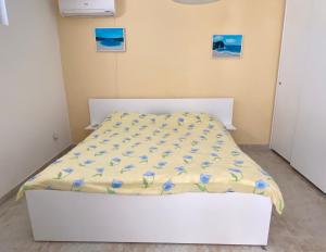 een wit bed met blauwe bloemen op een kamer bij Villa Casanego in Sutomore