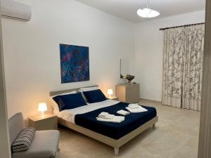 a bedroom with a bed and a chair in it at Le Gemme in Castellammare del Golfo