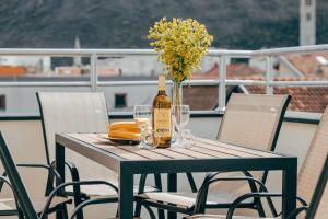 a table with a bottle of wine and a vase of flowers at Villa Hodžić in Mostar