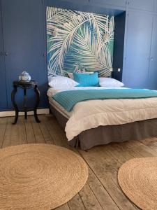a bedroom with a bed with blue walls and a table at La Maison de Jeanne in Dieppe