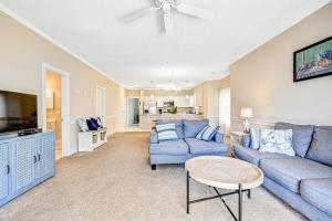 a living room with a blue couch and a tv at Carnation 101 in Myrtle Beach