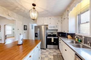 a kitchen with white cabinets and a stainless steel refrigerator at Leicht Haus in Fredericksburg