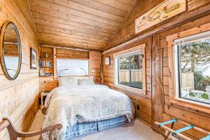 - une chambre dans une cabane en rondins avec un lit et 2 fenêtres dans l'établissement Cozy Cottage by the Sea, à Langley
