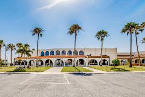 a parking lot in front of a building with palm trees at Long Island Village Unit 349 Sand Dollar Dr in Port Isabel