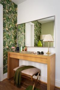 a dressing table with a mirror and a stool at Palm Grove Apartments in Torquay