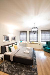 a bedroom with a bed and a couch and windows at Balans Studio Old Town in Gdańsk