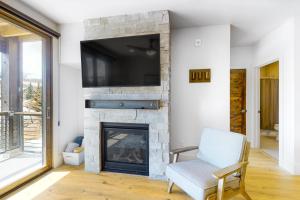 a living room with a fireplace with a tv above it at Blue River Flats Condos in Silverthorne