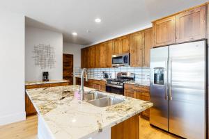 a kitchen with wooden cabinets and a stainless steel refrigerator at Blue River Flats Condos in Silverthorne