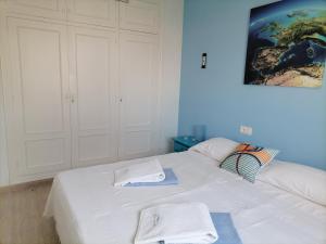 a bedroom with a white bed with towels on it at Vera Sol y Mar - Naturist Zone in Playas de Vera
