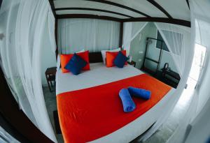 a canopy bed with two blue pillows on it at Seals Harbor Hotel in Weligama +40 photos