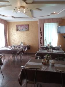 a dining room with tables and chairs and a tv at Вілла ,,Астері'' in Skhidnitsa
