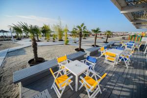 un patio con mesas y sillas en la playa en Nautic Sport Club, en Mamaia Nord – Năvodari