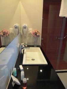 a bathroom with a sink and a mirror at Hotel Gema Luxury Suites in Montevideo