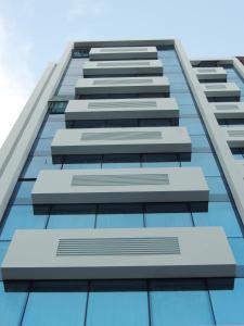 un edificio de cristal alto con cielo azul en el fondo en Hotel Gema Luxury Suites en Montevideo