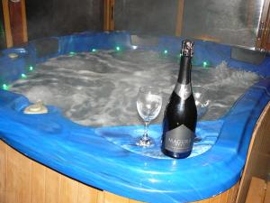 a bottle of champagne and a wine glass in a hot tub at Geto Apartment in Belogradchik