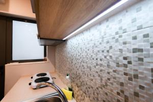 a bathroom with a sink and a tile wall at CENTRO PATRAS in Patra