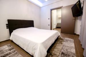 a bedroom with a bed and a flat screen tv at CENTRO PATRAS in Patra