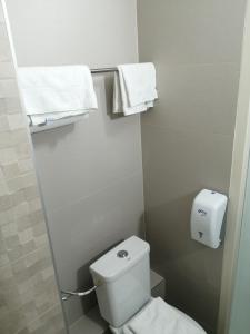 a small bathroom with a white toilet and towels at Hôtel Arc-En-Ciel - Entièrement Rénové in Mulhouse