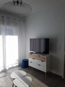 un soggiorno con TV a schermo piatto su un comò di Appartement le Michel ange a Briançon