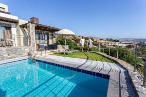 a swimming pool on the side of a house at Elounda Olea Villas And Apartments in Elounda