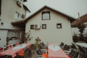 a restaurant with tables and chairs in front of a building at B&B Laguna in Đakovo