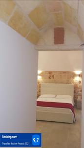 a bedroom with a white bed and a stone ceiling at Poggio Fiorito in Porto Cesareo
