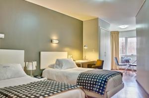 a hotel room with two beds and a table at Golf Apartamentos in Montevideo