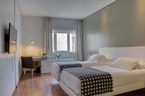 a hotel room with two beds and a desk at Golf Apartamentos in Montevideo