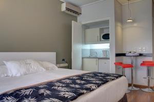 a bedroom with a large bed and a kitchen at Golf Apartamentos in Montevideo
