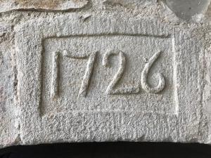 Una pared de piedra con el número. en Mas le Nogier Gites Apartments en Vesseaux