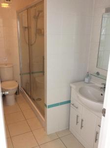een badkamer met een douche, een wastafel en een toilet bij The Epperstone in Llandudno