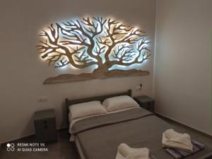 a bedroom with a tree mural on the wall at Despina garden view in Agia Galini