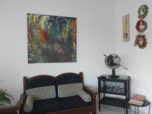 uma sala de estar com um sofá e uma pintura na parede em Pousada Solar dos Cavaleiros Mendes em Macaé
