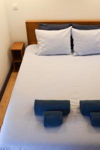 a bed with two blue pillows on it at Aurora Sky in Porto