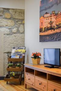 a living room with a tv and a desk at Aurora Sky in Porto