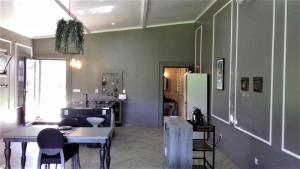 a living room with a table and a refrigerator at Gala Da Vittoria in Capelas