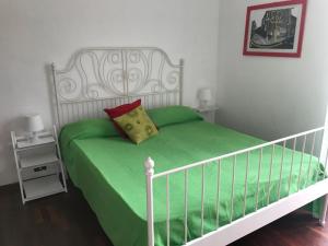 a bedroom with a bed with a green comforter at Salto del Gatto in La Spezia